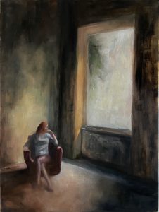 Picture of a woman in a big room looking outside the window
